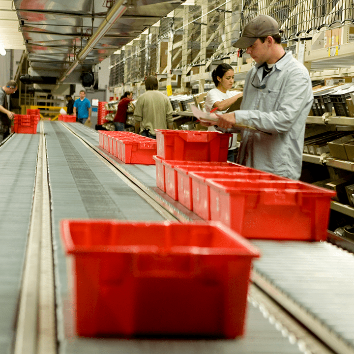Man filling totes on a conveyor