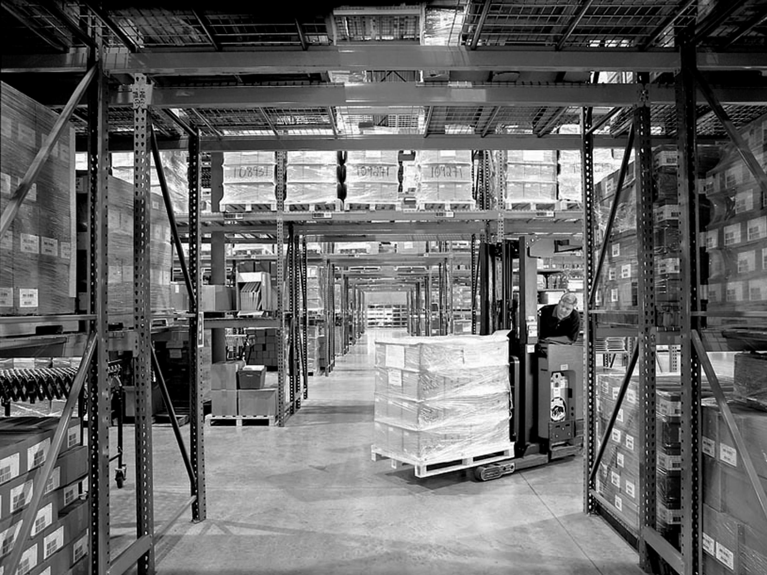 forklift moving pallets of product in warehouse
